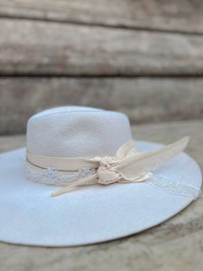 Elegante cappello bianco decorato con pizzo, cristalli, piuma e nastro